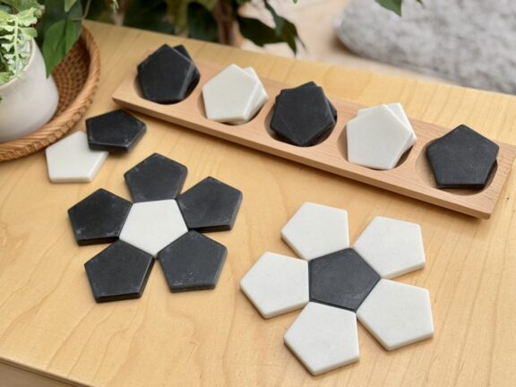 black and white Pentagon stones laid on a table in a 5 petal flower pattern