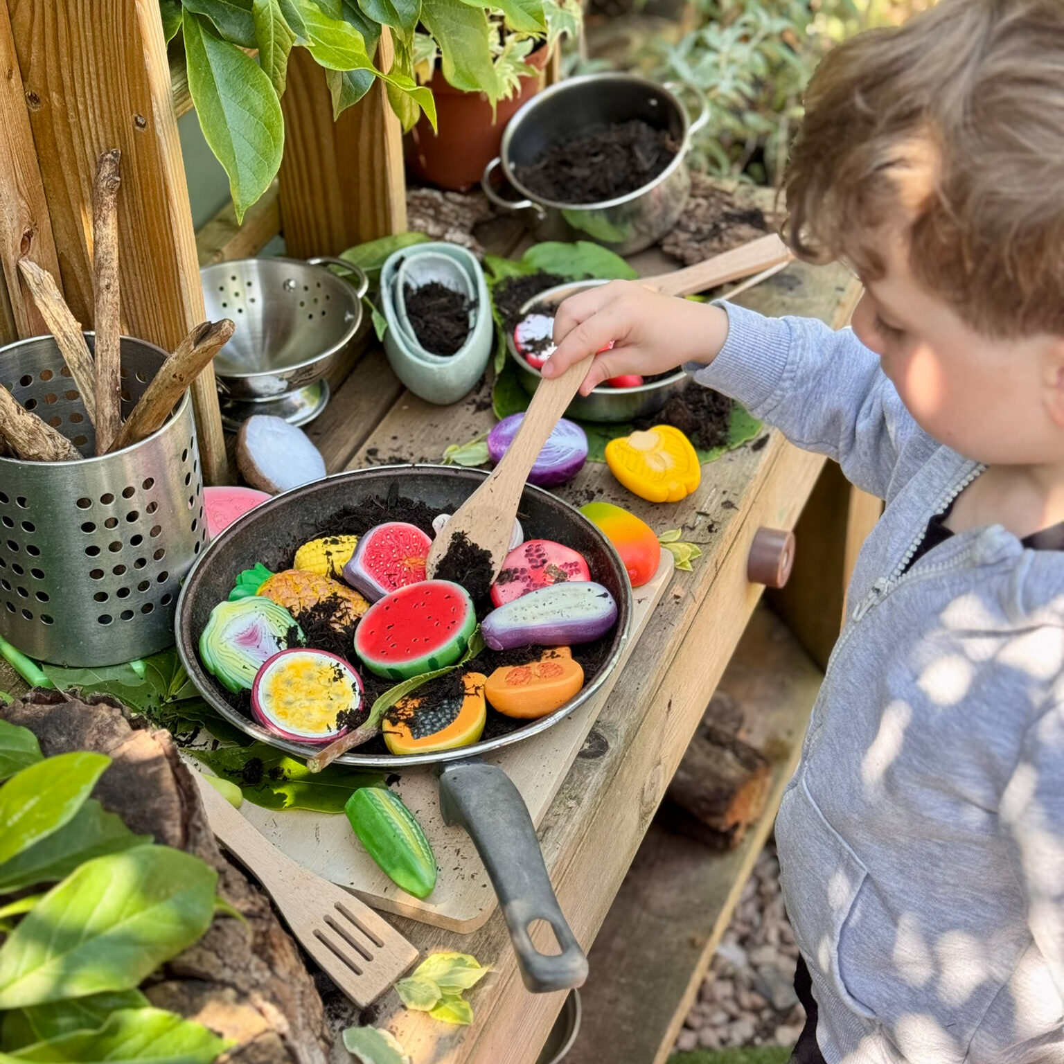 boy in mid kitchen with world kitchen sensory play stones